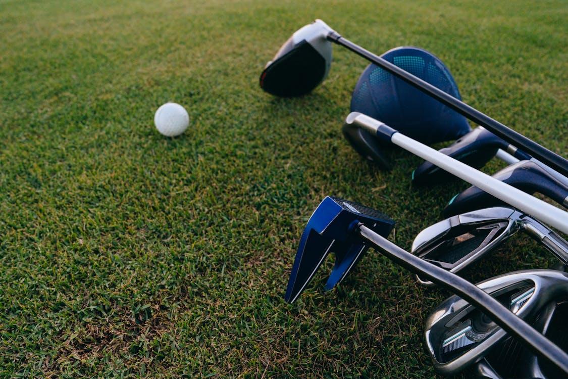 Clubs de golf et balle posés sur le gazon d'un parcours