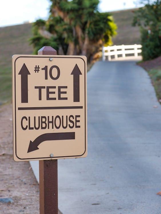 Panneau de direction sur un parcours de golf indiquant les tees de départ